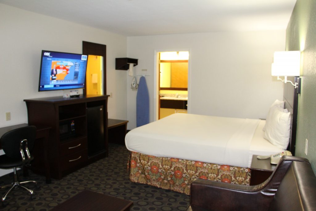 King room with desk, dresser and bathroom entry